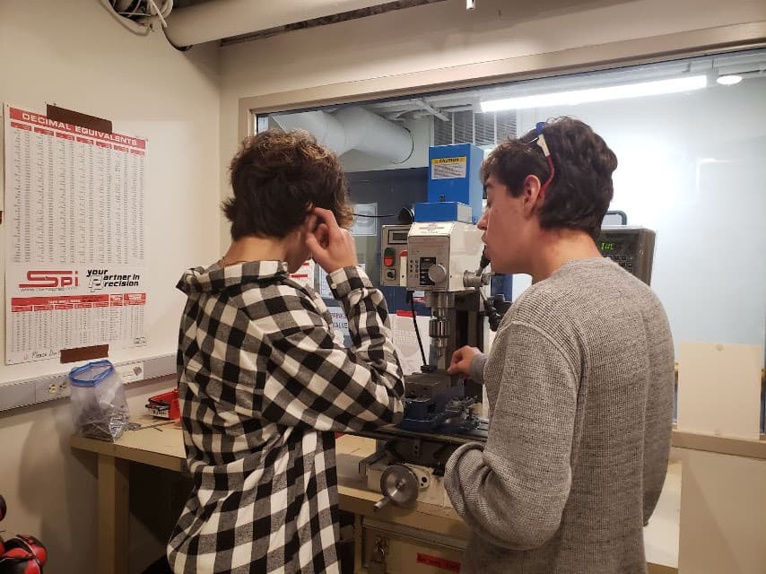 Owen '25 and Brandon '23 working at the mill during a mechanical training
